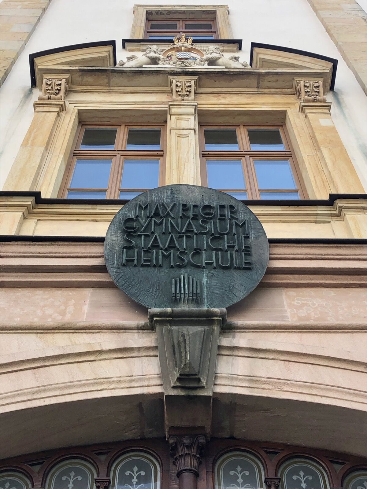 The stone main portal of 1880 at the Amberg school building, with a round-arched doorway and carved detail above.