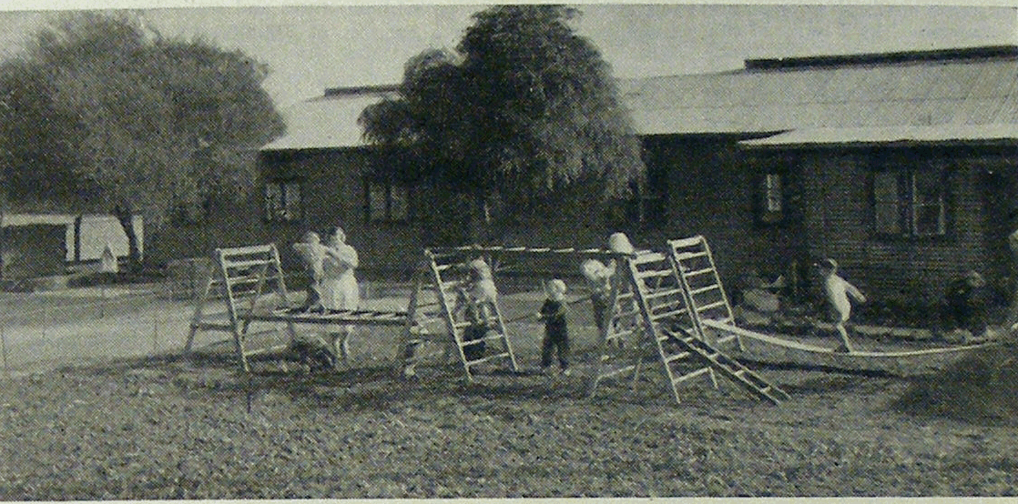 Children using climbing equipment outside the camp kindergarten.