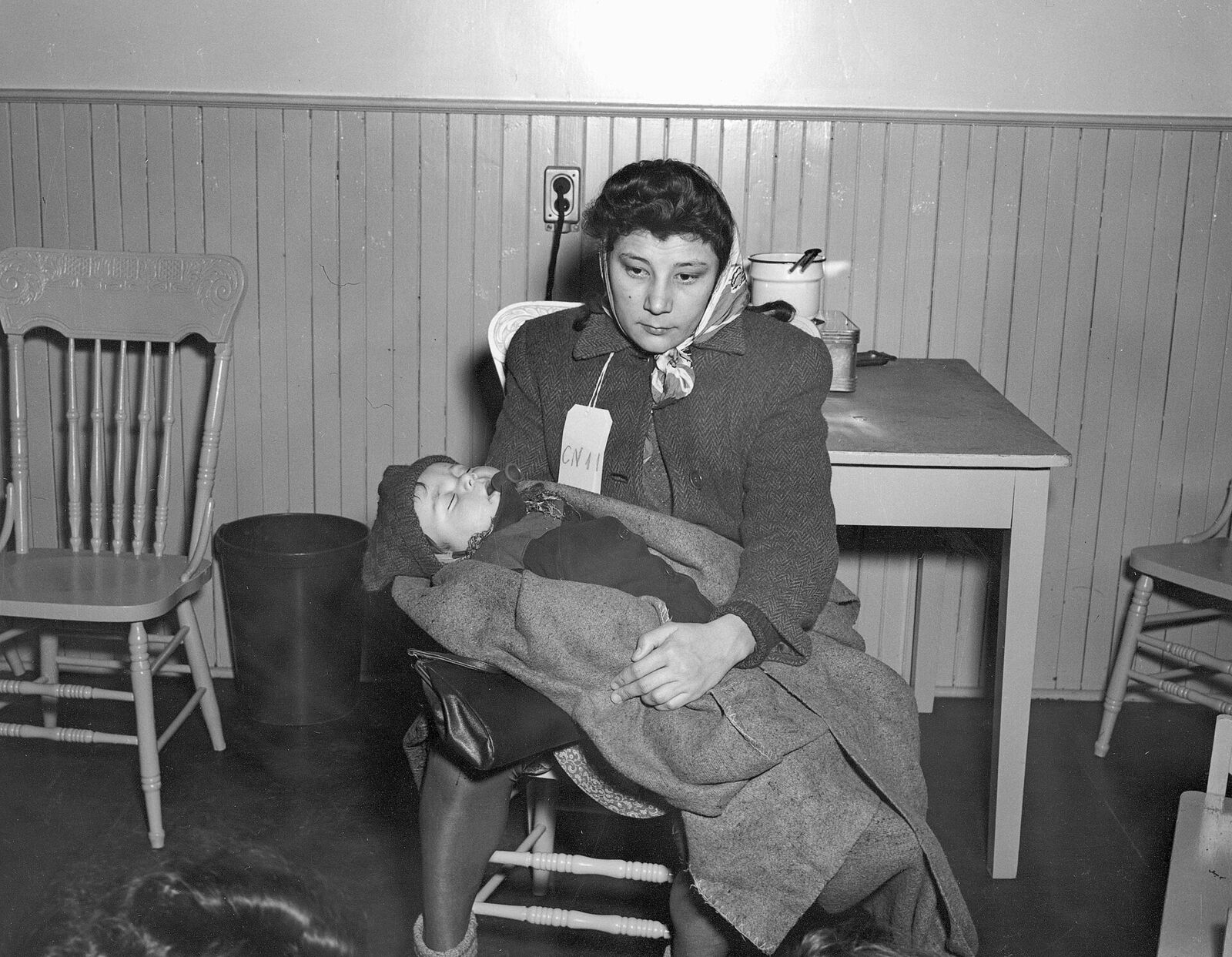 An immigrant woman holding a baby at Pier 21, Halifax, in 1948.