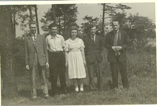 Five people standing together outside a building at the camp, photographed in June 1948.