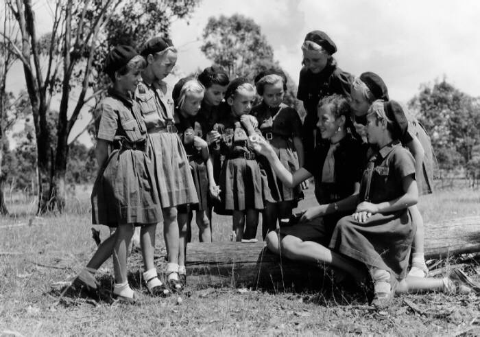 Girls and adult women gathered outdoors.