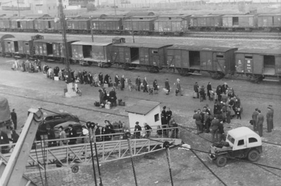Displaced persons carrying bundles and cases walk up the gangway of the General Stuart Heintzelman at Bremerhaven in October 1947.