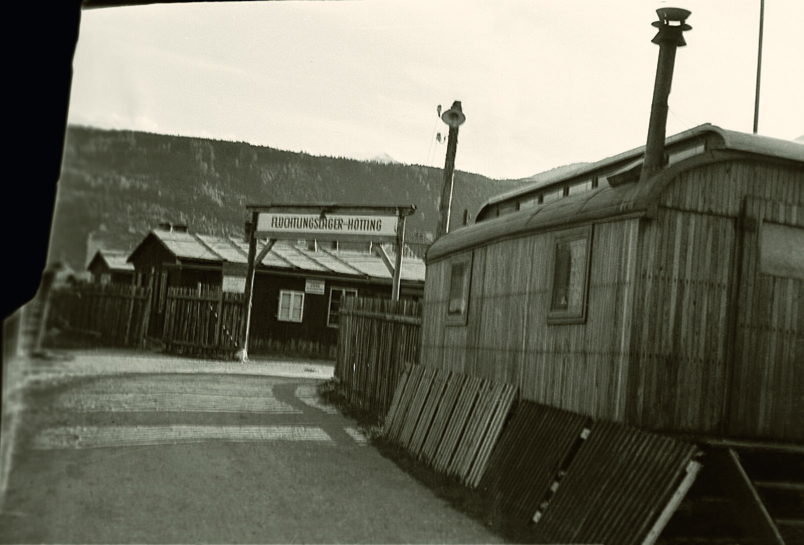 The entrance and wooden huts of the Hötting refugee camp.