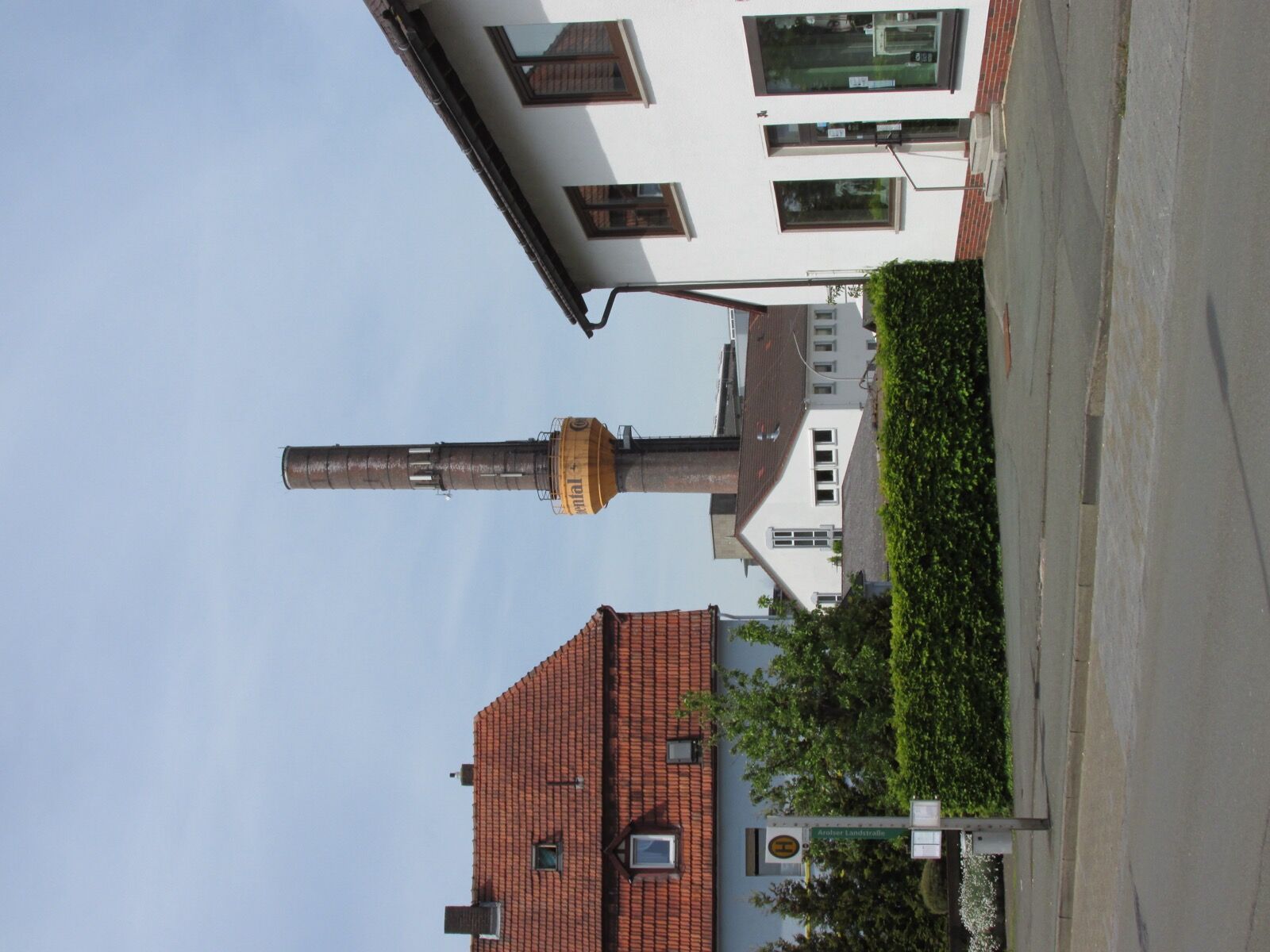 The tall brick chimney and works buildings of the Continental factory at Korbach, seen across rooftops from the Arolser Landstraße.