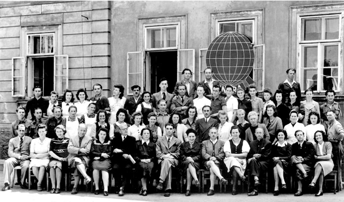 A group outside the Leoben children’s home beneath an UNRRA emblem, 1947.