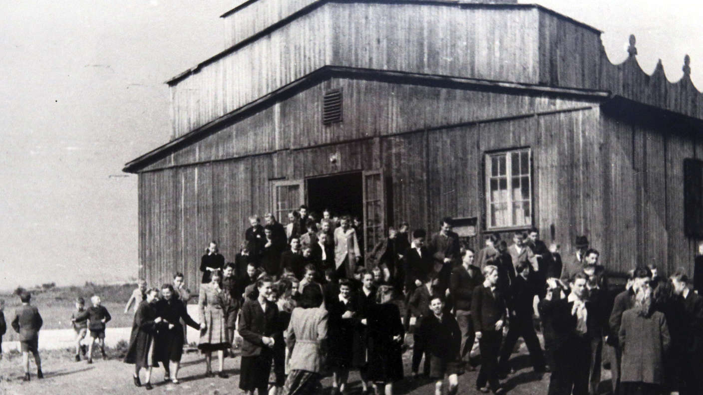 An audience leaving the wooden camp cinema