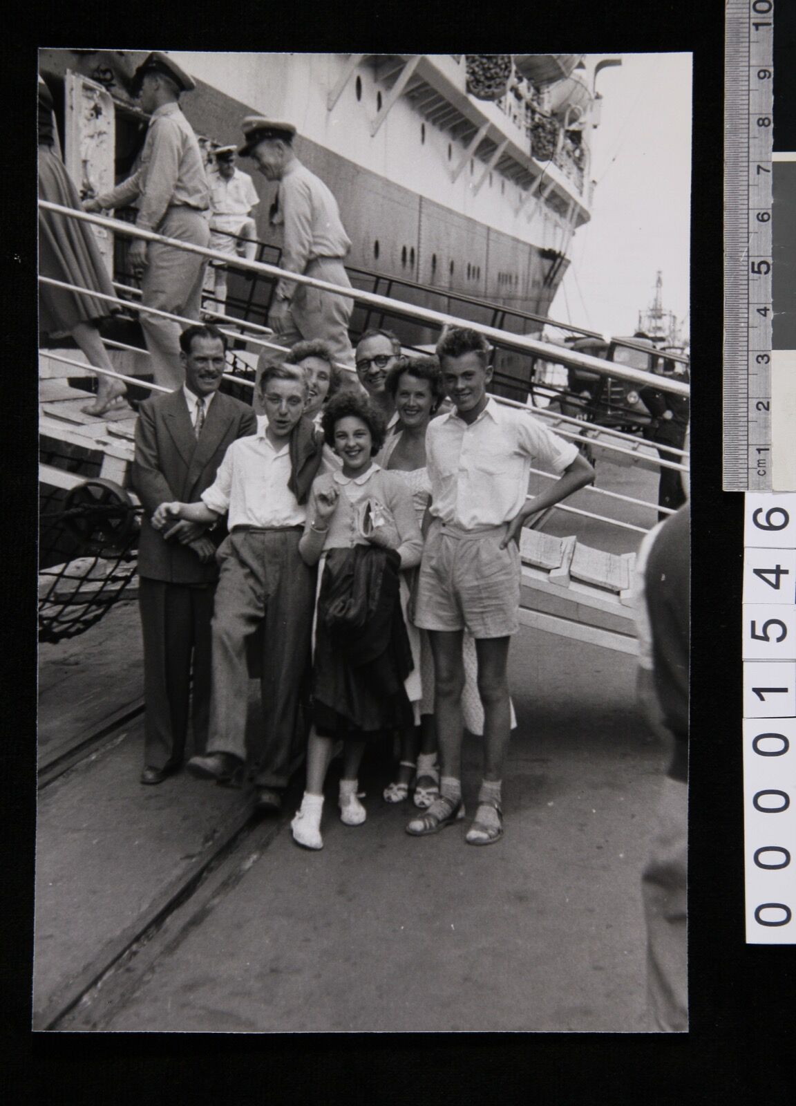 Passengers standing on the wharf at Fremantle beside the passenger ramp of the migrant ship New Australia.