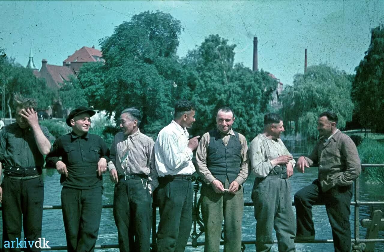 Seven men beside a park bridge