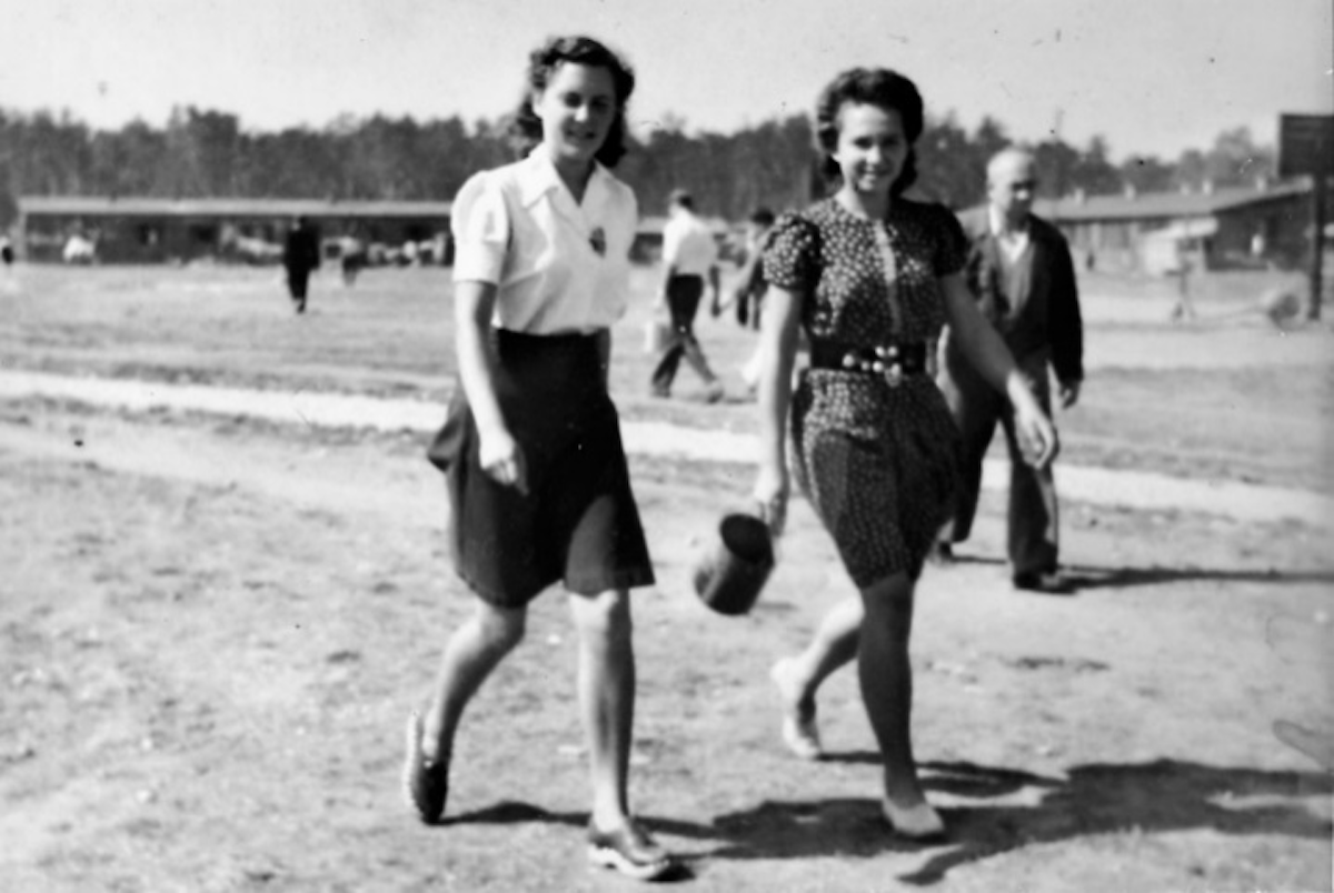 People on the way to collect supper at Schleißheim, with camp barracks behind.
