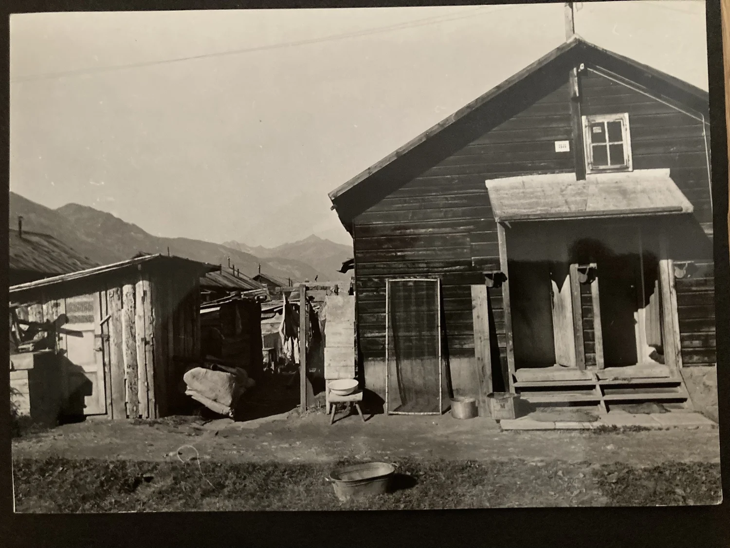 A camp dwelling at Spittal with improvised sheds and household washing vessels.