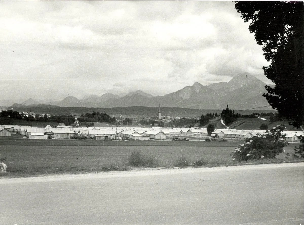 Rows of long wooden huts on flat ground below Villach and the Karawanken, 1947.