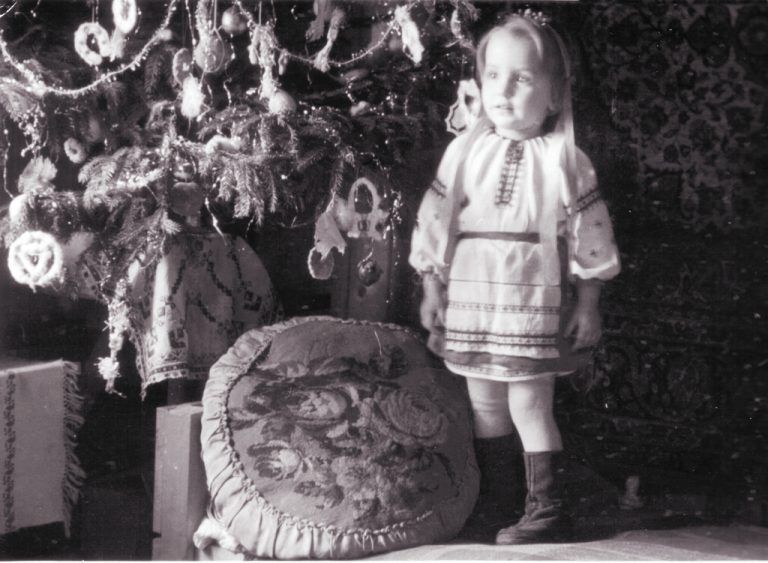 A child beside a Christmas tree inside Vorkloster Camp.