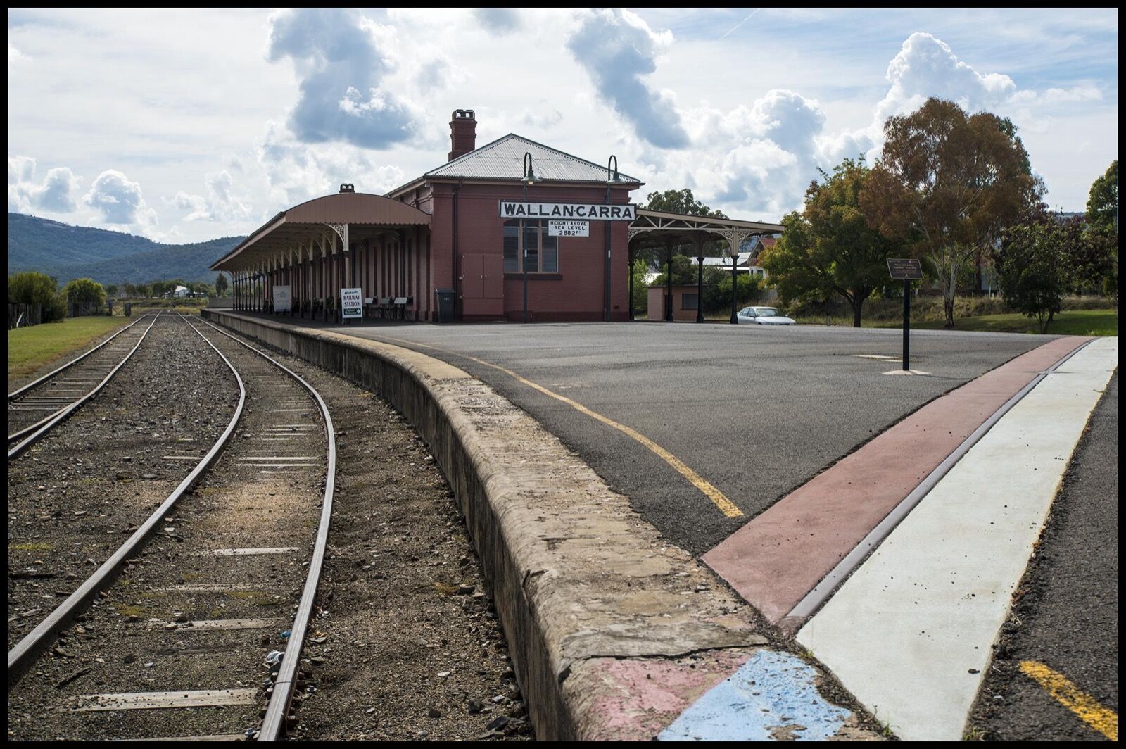 The long platform of Wallangarra railway station, with the state border marked between the Queensland and New South Wales sides.